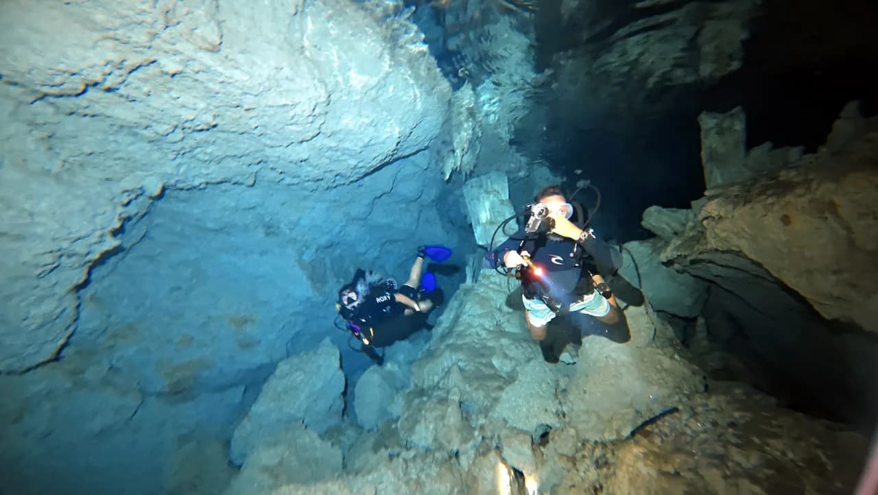 Diver with a torch in a flooded cave